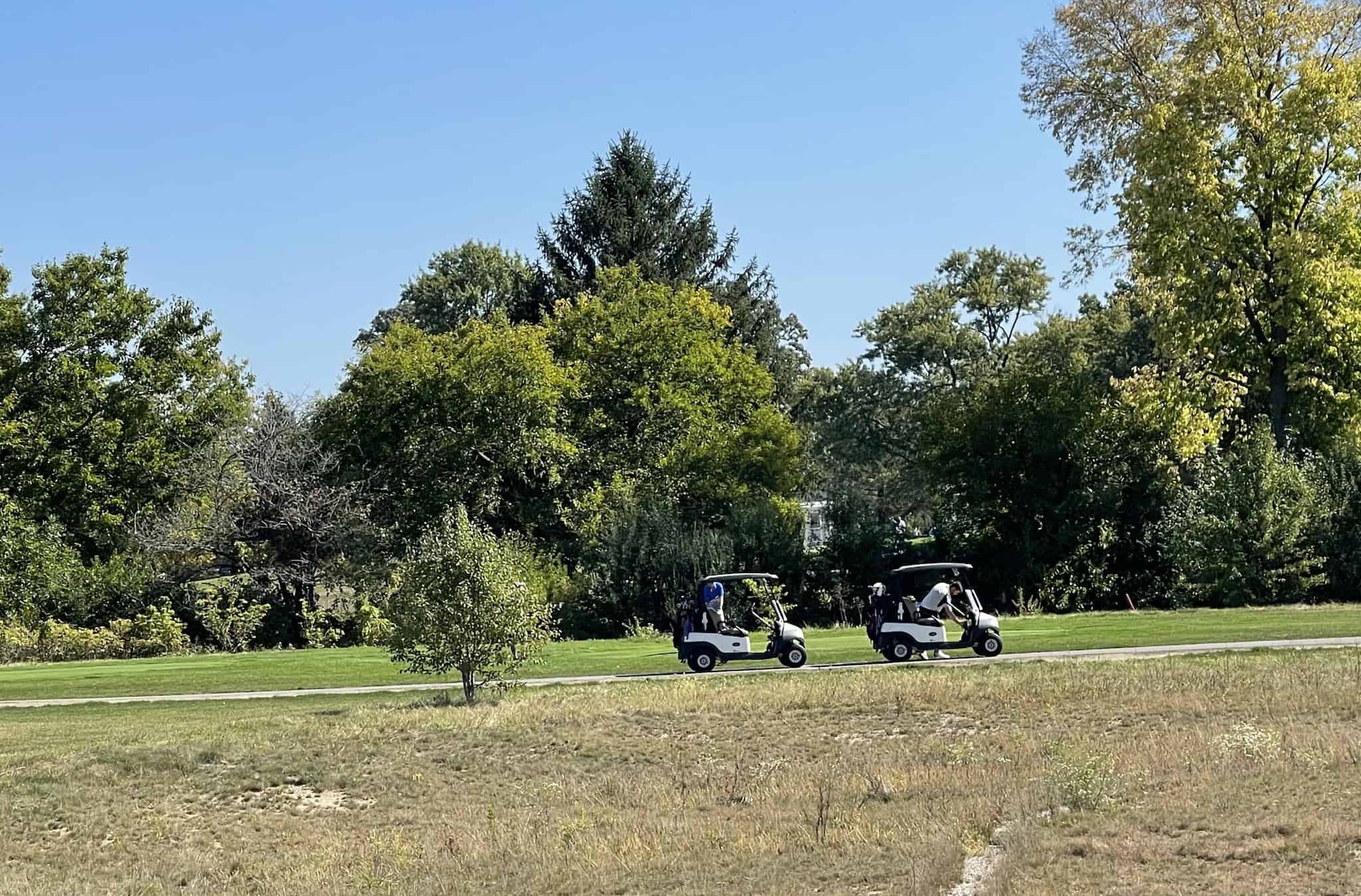Golf carts pass along the path at the Golf Club of Indiana